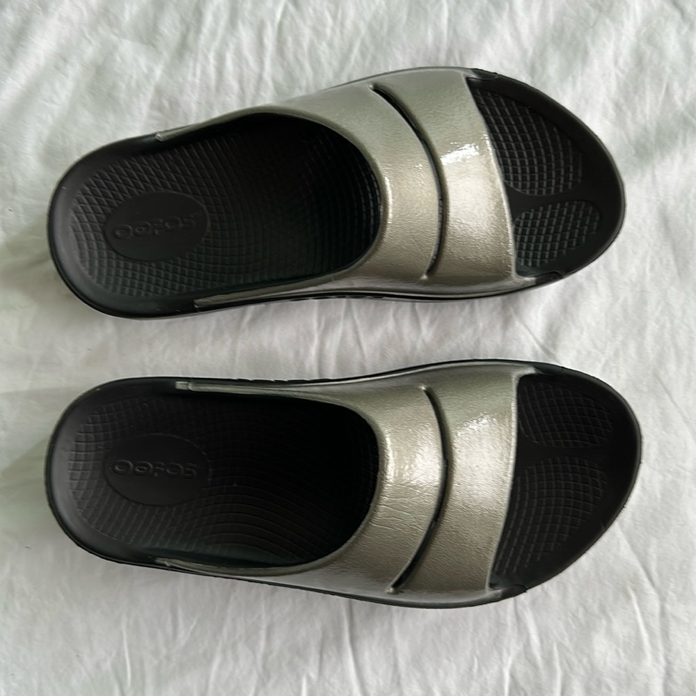 Oofos Women’s Ooahh Recovery Sport Slide. W7 Shiney goldish bronze color